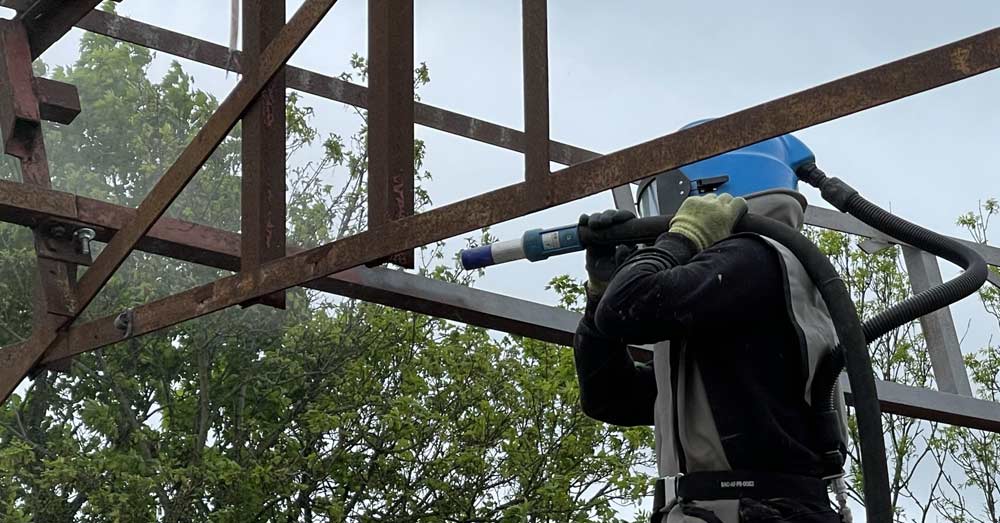 Rust removal from metal frame at construction project near Reading, Berkshire